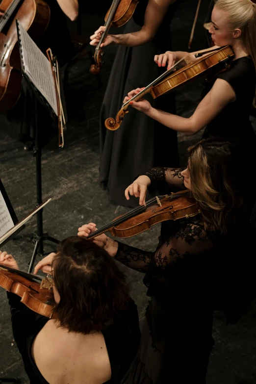 a group of people that are playing musical instruments, standing on top of a violin