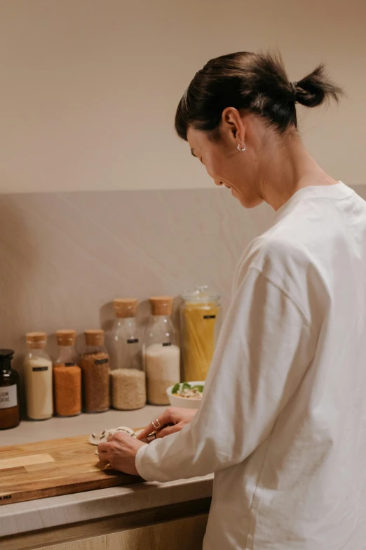 a woman in a kitchen preparing food on a cutting board, by Sengai, unsplash, full body profile, apothecary, inspect in inventory image, close-up photograph