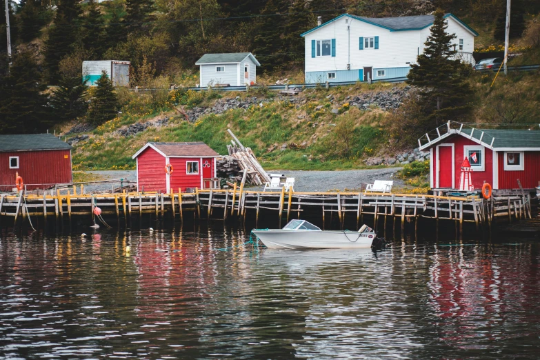 a boat floating on top of a body of water, by Carey Morris, pexels contest winner, several cottages, gauthier leblanc, harbour, thumbnail