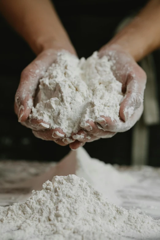 a person holding a pile of flour in their hands, a portrait, by Helen Stevenson, trending on unsplash, process art, porcelain organic, promo image, medium close up, where a large