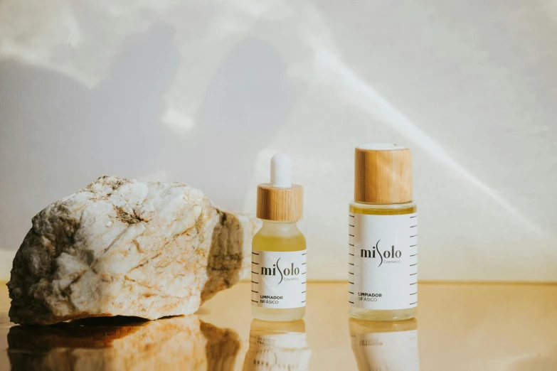 a couple of bottles sitting on top of a table, inspired by Sawa Sekkyō, featured on unsplash, lyco art, photoshoot for skincare brand, mihoyo, shades of gold display naturally, explorer