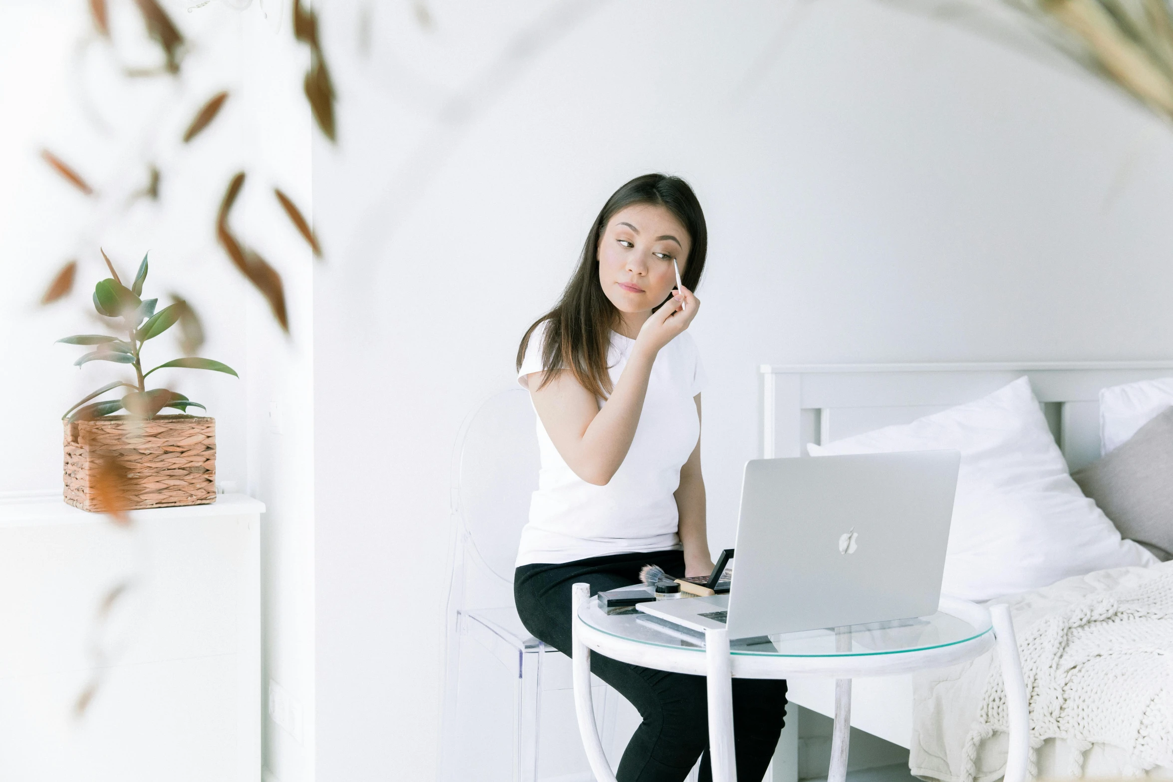 a woman sitting on a bed talking on a cell phone, a cartoon, trending on pexels, using a macbook, dressed in a white t shirt, with professional makeup, asian women