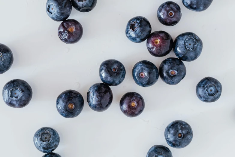 a pile of blueberries sitting on top of a white table, profile image, background image, uncrop, product shot