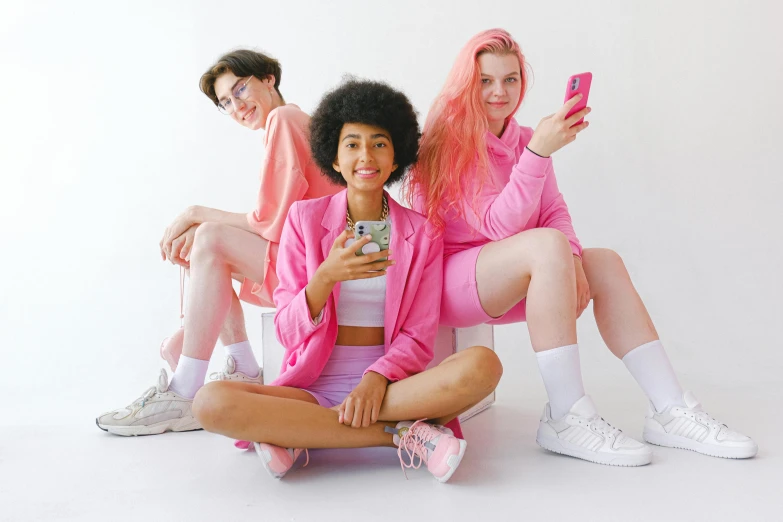 a group of young women sitting next to each other, trending on pexels, antipodeans, pink clothes, phone photo, three futuristic princes, featuring pink brains