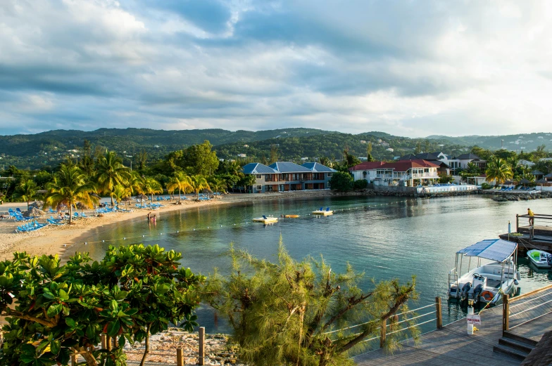 a large body of water next to a beach, a portrait, jamaica, small port village, multiple stories, sun down