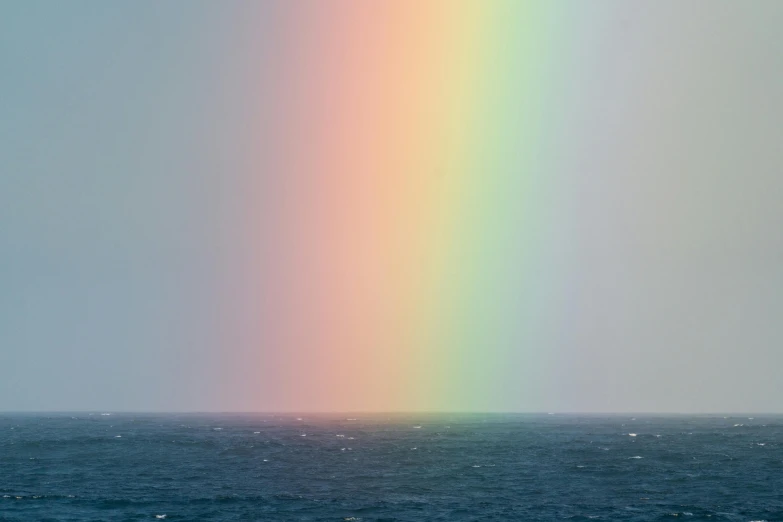 a rainbow in the sky over a body of water, a photo, unsplash, color field, hiroshi sugimoto, open ocean, tetrachromacy, pearlescent