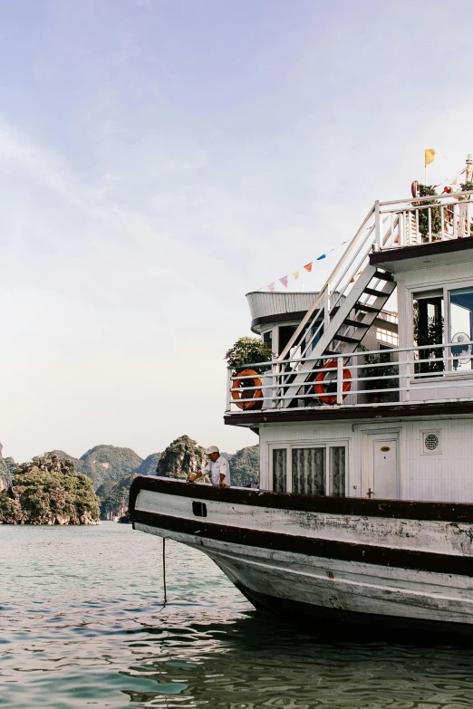 a large white boat floating on top of a body of water, vietnam, balcony, square, wedding