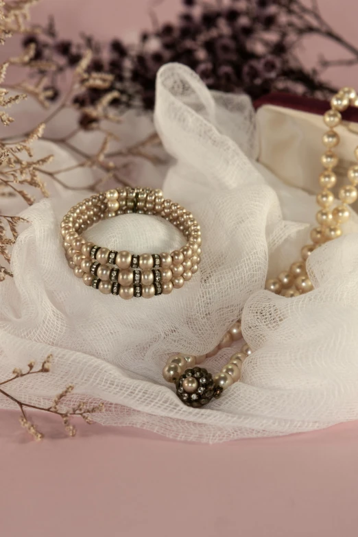 a bunch of jewelry sitting on top of a white cloth, inspired by Perle Fine, renaissance, sepia tones, 1 9 2 0 s style, medium-shot, pearl silverplate