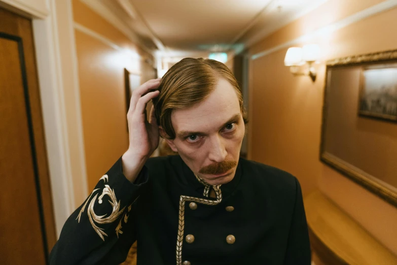 a man that is standing in a hallway, an album cover, inspired by Mikhail Yuryevich Lermontov, unsplash, imperial portrait, looks like domhnall gleeson, mutton chops, press photos