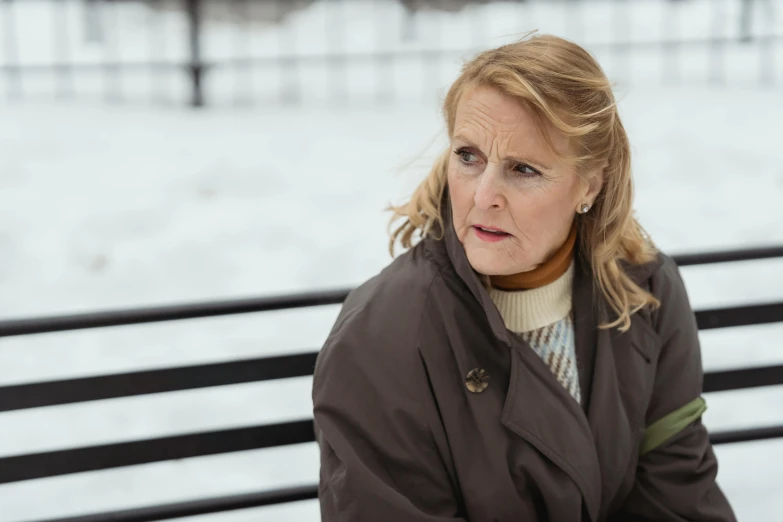 a woman sitting on a bench in the snow, a portrait, inspired by Celia Fiennes, pexels, looking confused, square, older woman, production still