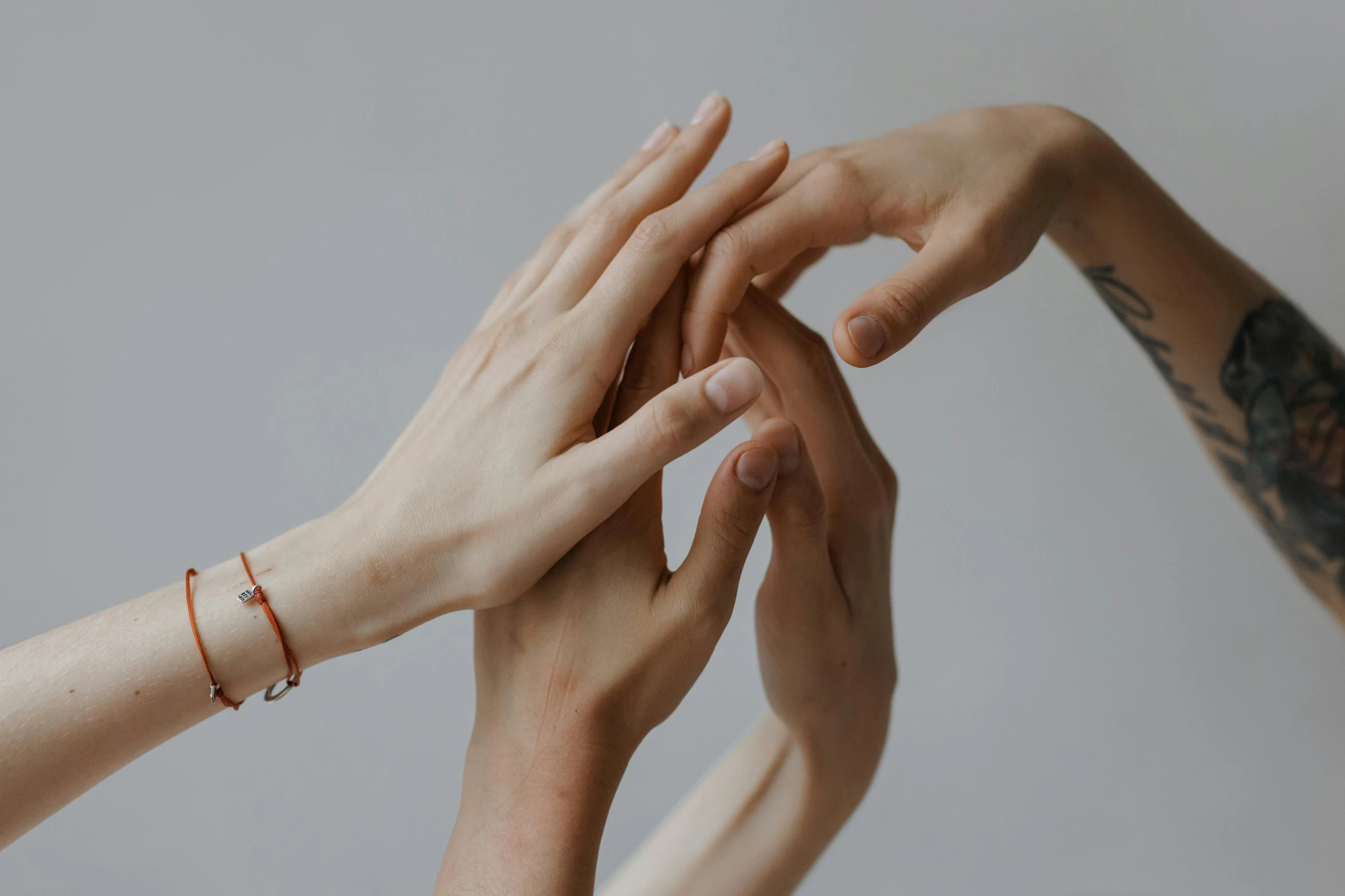 a group of people putting their hands together, by Emma Andijewska, trending on pexels, aestheticism, mary jane ansell, background image, graceful arms, holding an epée