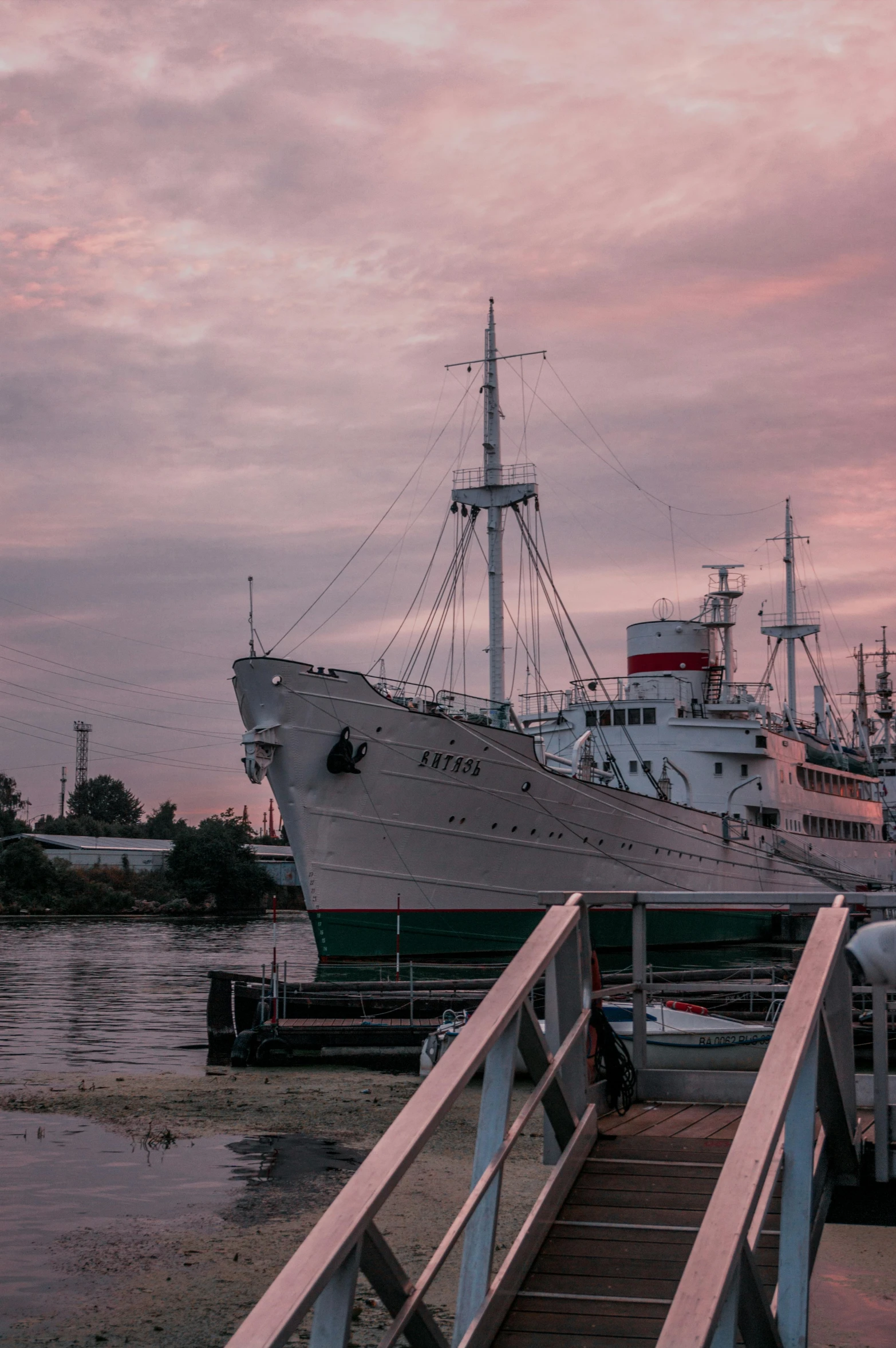 a boat that is sitting in the water, a colorized photo, by Sven Erixson, pexels contest winner, modernism, ships in the harbor, pink skies, espoo, stern like athena