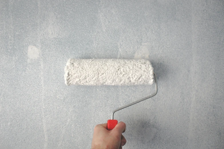 a person painting a wall with a paint roller, a photorealistic painting, inspired by Julio Larraz, unsplash, on grey background, background image, detailed product image, stippled walls