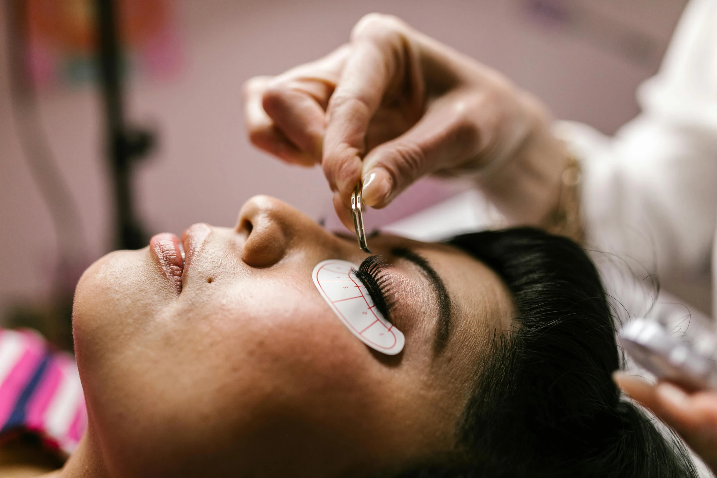 a woman getting her eye examined by a doctor, by Julia Pishtar, trending on pexels, hurufiyya, long lashes, laying down, diecut, 33mm photo