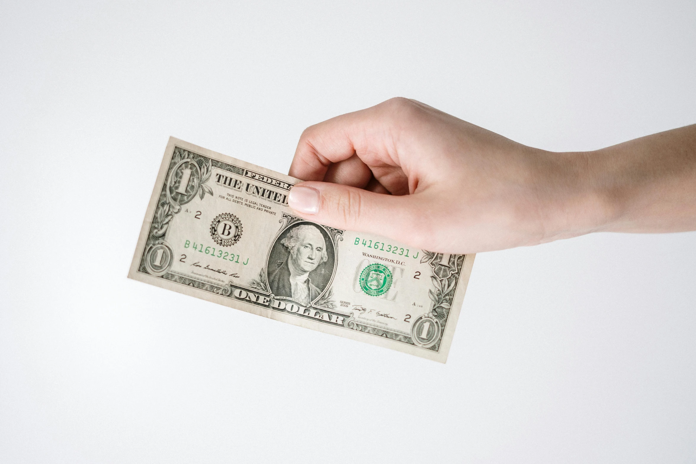 a person holding a one dollar bill in their hand, by Ben Zoeller, trending on unsplash, photorealism, on a white background, product introduction photo