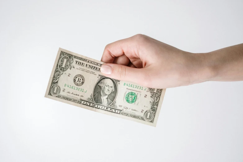 a person holding a one dollar bill in their hand, by Ben Zoeller, trending on unsplash, photorealism, on a white background, product introduction photo