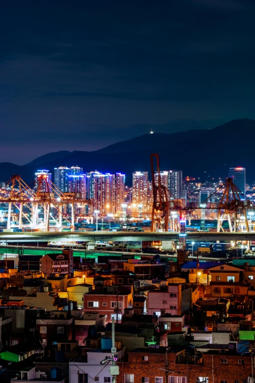 an aerial view of a city at night, container ship, shenzhen, with a city in the background, square
