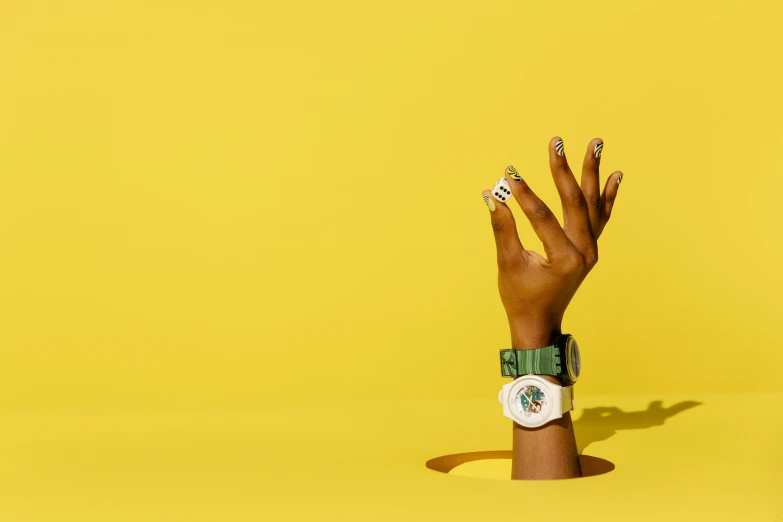 a close up of a person's hand with a watch on it, an album cover, yellow backdrop, skin painted with green, instagram photo, wolfy nail