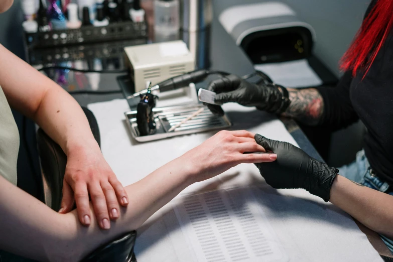 a woman getting her nails done at a salon, a tattoo, by Adam Marczyński, trending on pexels, hyperrealism, mechanical limbs, ots shot, lachlan bailey, from the elbow