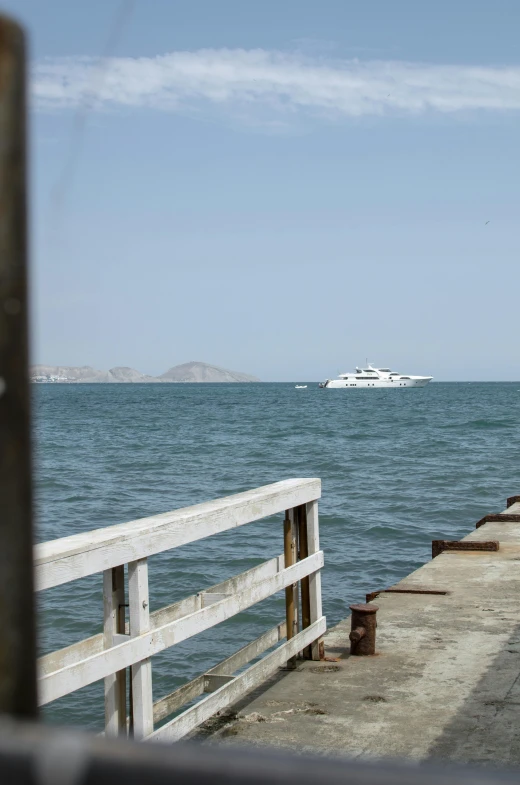 a body of water with a boat in the distance, happening, sitting on a wooden dock, golden gate, mexico, in 2 0 1 2