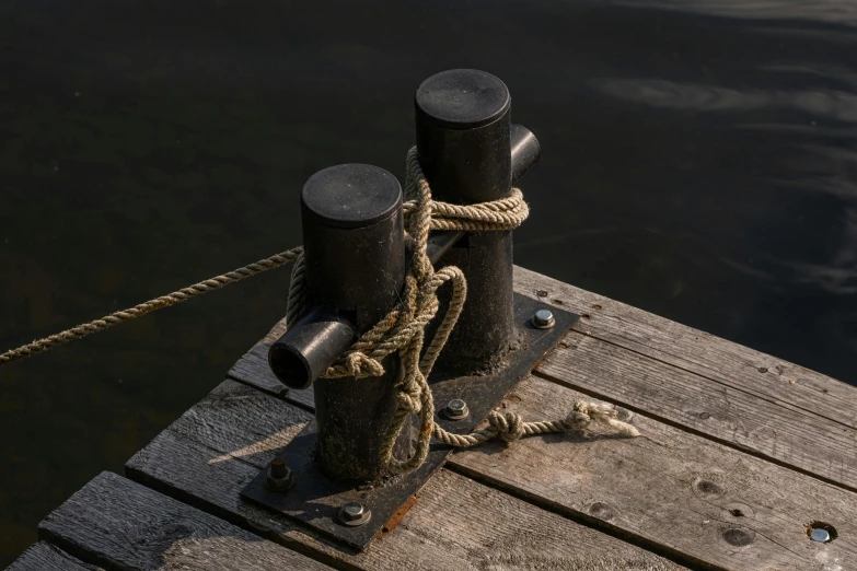 a couple of poles sitting on top of a wooden dock, inspired by Sarah Lucas, unsplash, new sculpture, dark eye sockets, texture detail, moored, paul barson