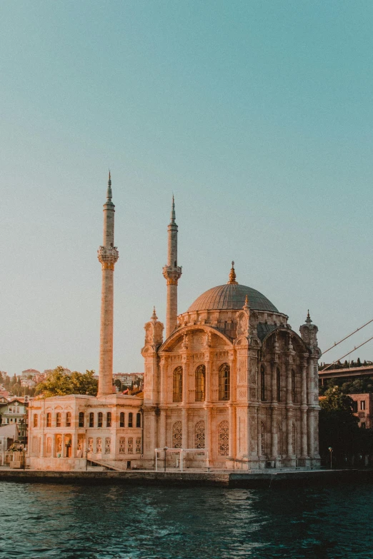 a large building sitting on top of a river next to a bridge, a colorized photo, pexels contest winner, hurufiyya, with great domes and arches, 256x256, turkey, neoclassical style