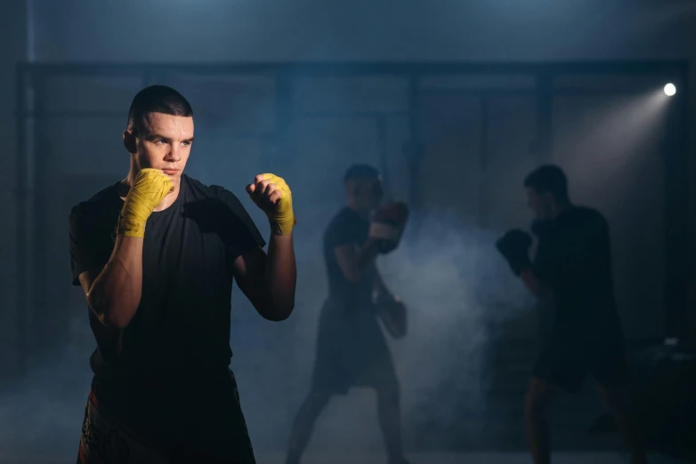 a man in a black shirt and yellow gloves, shutterstock, fighting stance energy, atmospheric photo, local gym, award - winning