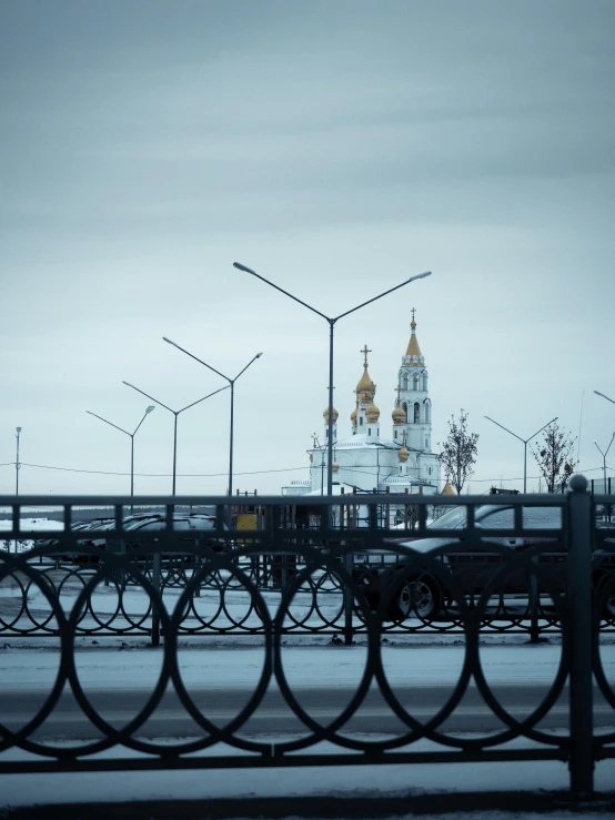 a bridge over a body of water with a church in the background, by Andrei Kolkoutine, pexels contest winner, dieselpunk norilsk city, white and gold, square, streetlamps