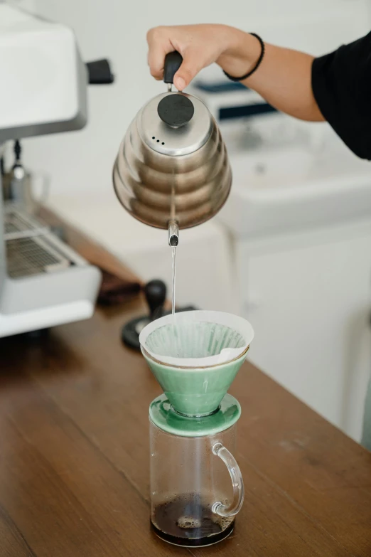 a person pours water into a coffee pot, a still life, by Robbie Trevino, dynamic angled shot, green, japanese, cleanest image