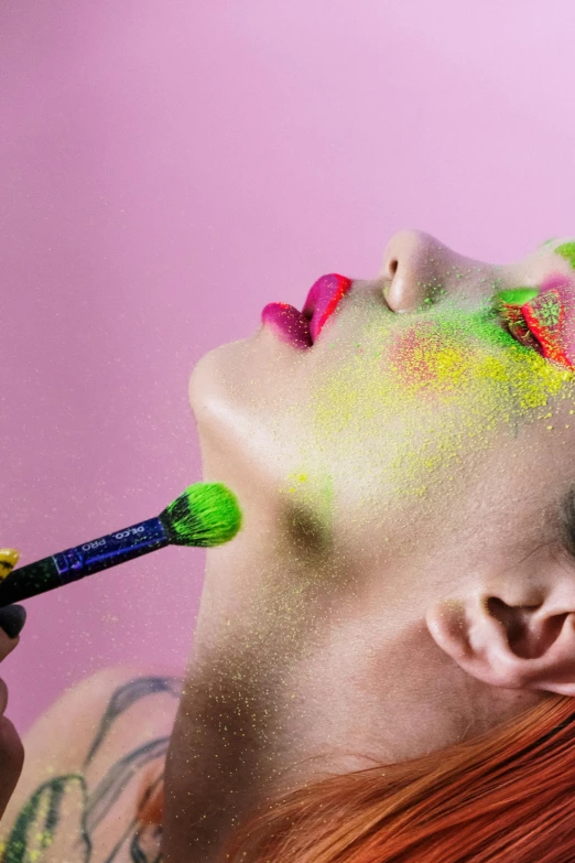 a woman that has some paint on her face, an album cover, inspired by Bert Stern, trending on pexels, flourescent colors, holding a paintbrush, lush, okuda