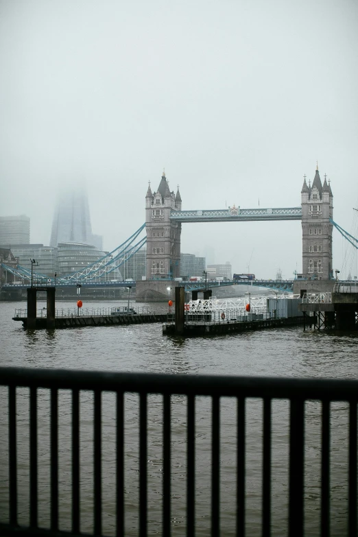 a body of water with a bridge in the background, on a wet london street, under a gray foggy sky, two towers, 2022 photograph