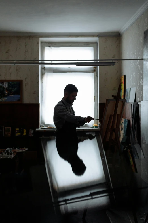 a man sitting at a desk in a dark room, a silk screen, arbeitsrat für kunst, ukraine. photography, trending photo, beautiful daylight, ignant