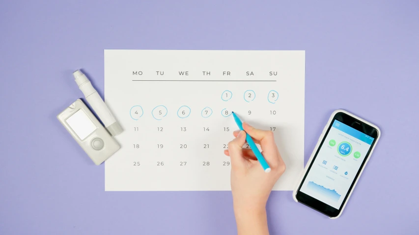 a person writing on a piece of paper next to a cell phone, blue and purple colour scheme, female calendar, holding syringe, product shot