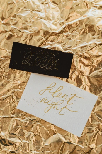 a piece of foil sitting on top of a table, by Julia Pishtar, trending on unsplash, “modern calligraphy art, christmas night, diptych, business card