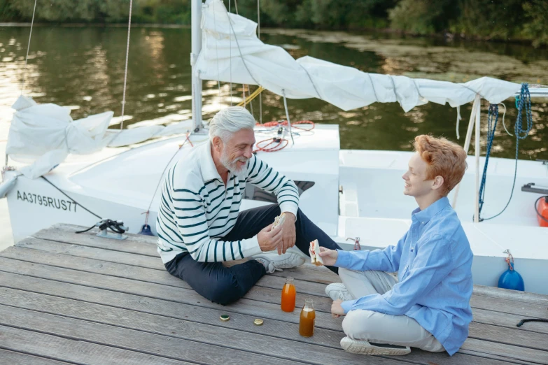 a man and a woman sitting on a dock next to a body of water, sail, older male, snacks, 15081959 21121991 01012000 4k