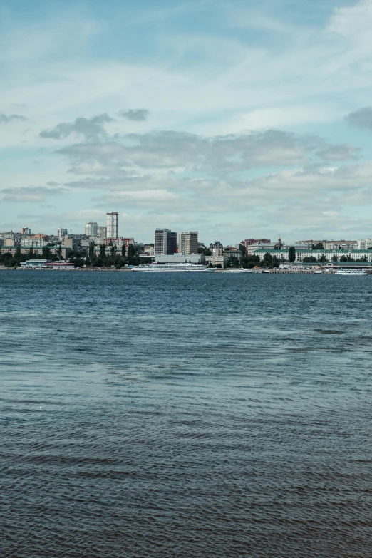 a large body of water with a city in the background, inspired by Wilhelm Marstrand, unsplash, hurufiyya, espoo, low quality photo, ultrawide image, shoreline