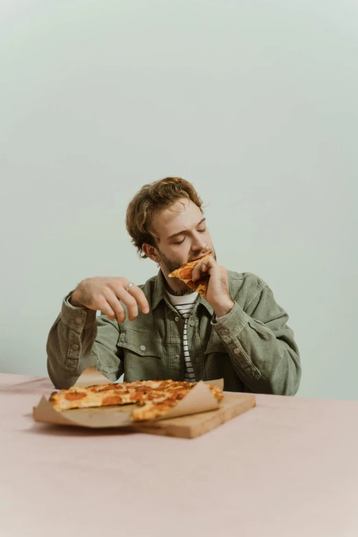 a man sitting at a table eating a slice of pizza, slightly minimal, promo image, dylan kowalsk, plain background