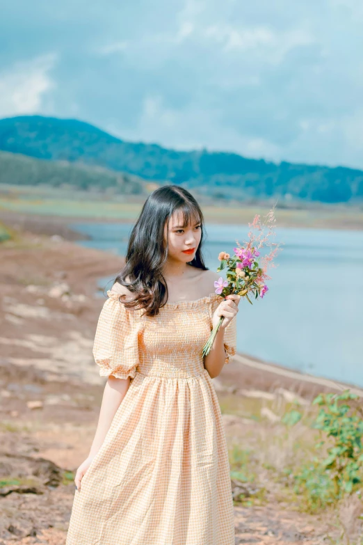 a woman in a dress holding a bunch of flowers, by Tan Ting-pho, unsplash, romanticism, ulzzang, lake in the background, 15081959 21121991 01012000 4k, orange pastel colors