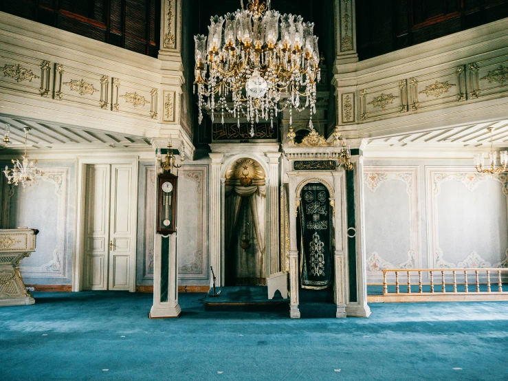 a room with a chandelier and blue carpet, trending on unsplash, baroque, turkey, tall, fan favorite, tombs