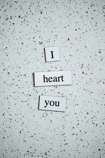 a piece of paper with the words i heart you written on it, by Elaine Hamilton, unsplash, concrete poetry, magnetic, ilustration, white