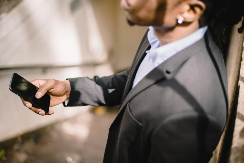 a man in a suit holding a cell phone, pexels contest winner, jemal shabazz, attention to details, ( ( theatrical ) ), wearing jacket