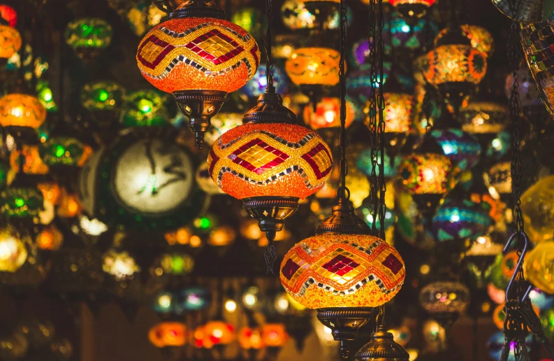 a bunch of colorful lights hanging from a ceiling, a mosaic, trending on pexels, middle eastern style vendors, red and orange glow, middle eastern skin, globes