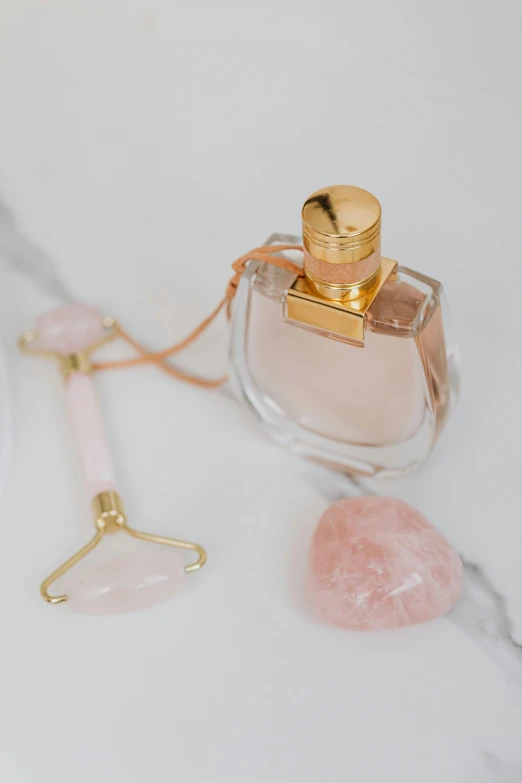 a bottle of perfume sitting on top of a table, inspired by Hedi Xandt, trending on pexels, rose quartz, gemstones, vibrating, close up shot of an amulet