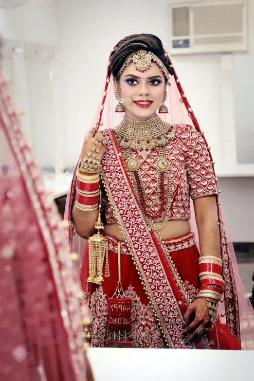 a woman that is standing in front of a mirror, inspired by Saurabh Jethani, pexels contest winner, wearing red attire, silver red white details, wearing a wedding dress, walking towards camera