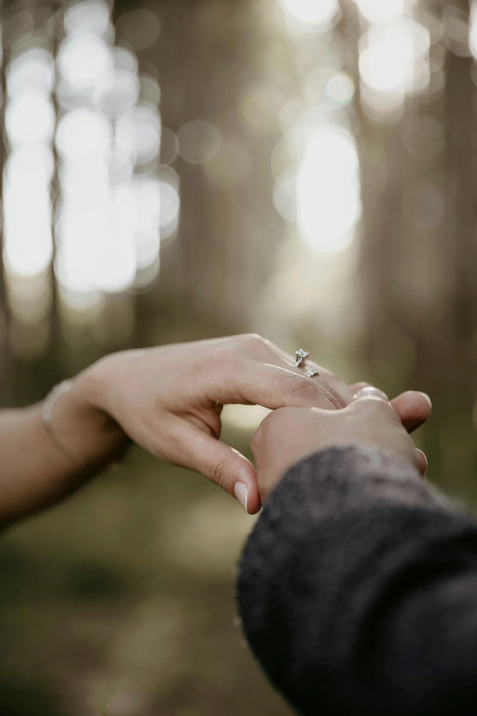 a man and a woman holding hands in the woods, ring lit, instagram post, cinematic shot ar 9:16 -n 6 -g, grey