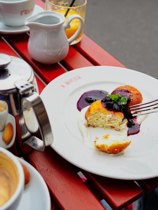 a close up of a plate of food on a table, a photo, inspired by Barthélemy Menn, trending on unsplash, art nouveau, in a sidewalk cafe, breakfast, flan, thumbnail