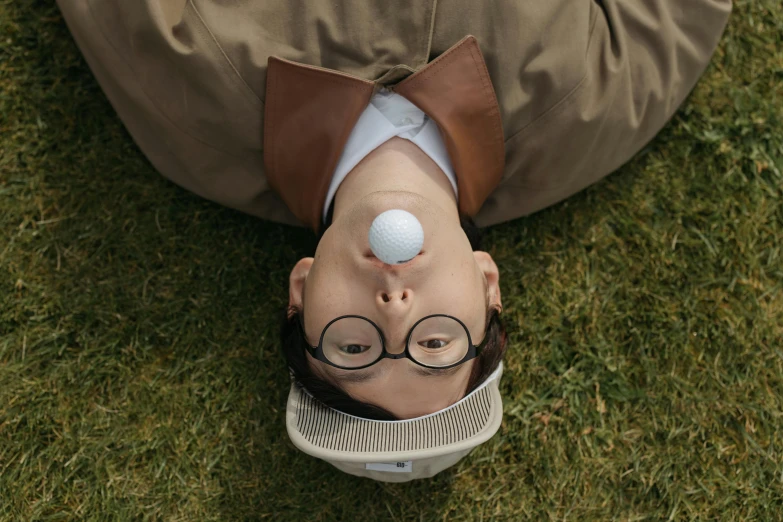 a man laying on top of a lush green field, unsplash, photorealism, round glasses potter, sangsoo jeong, golf digest, still image from tv series