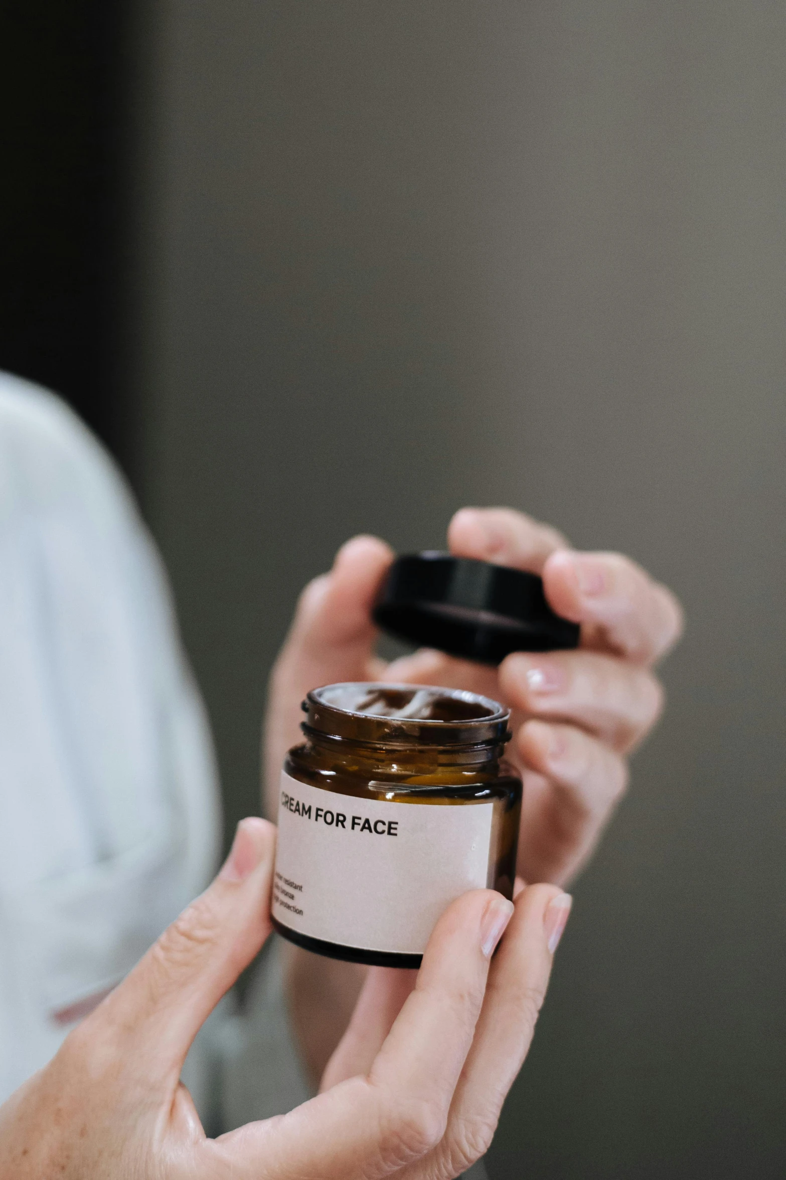 a close up of a person holding a jar of cream, unsplash, detailed product image, facing front, pack, brown