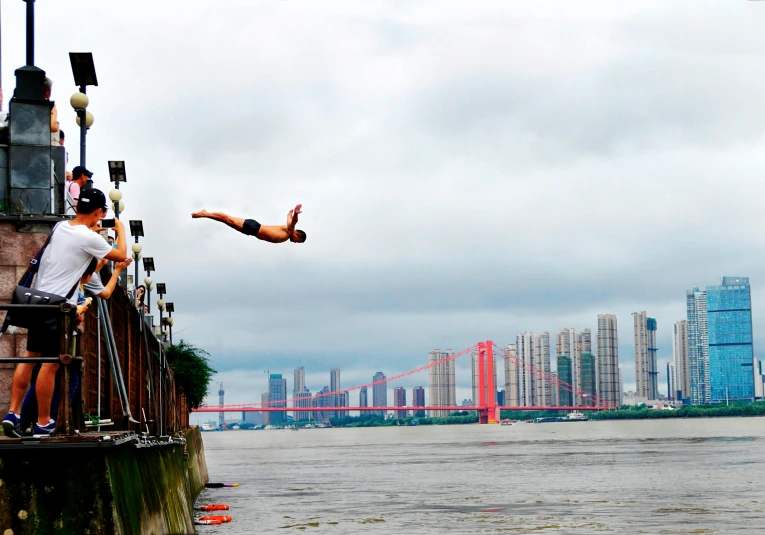 a group of people standing on top of a pier next to a body of water, inspired by Fei Danxu, happening, olympic diving springoard, shanghai city, slide show, beginner