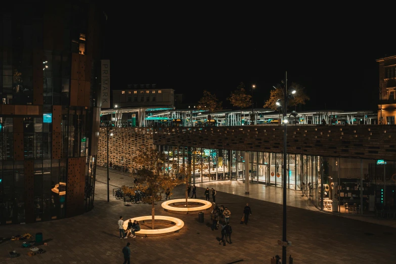 a group of people walking around a city at night, coventry city centre, large windows to forest at night, underground city, vast library